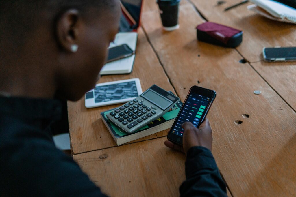 finance tracker app used on a smartphone with a calculator during an everyday spending review.